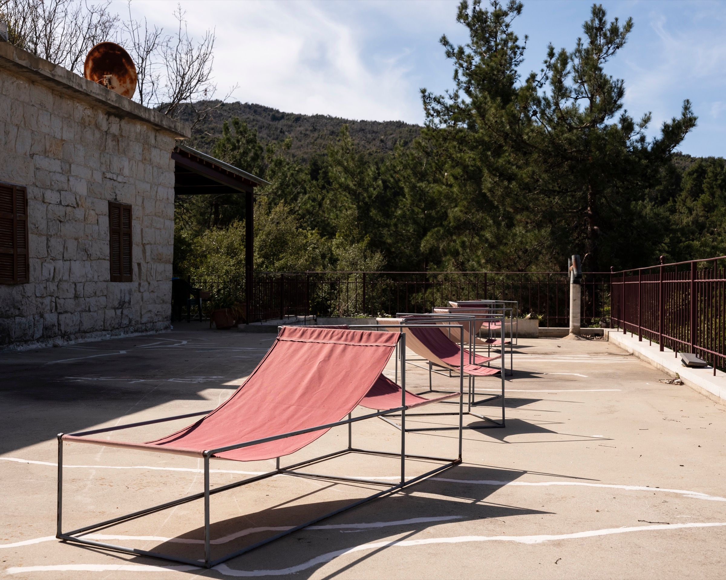 Canvas sling chairs on the stone terrace looking out over the pine valley
