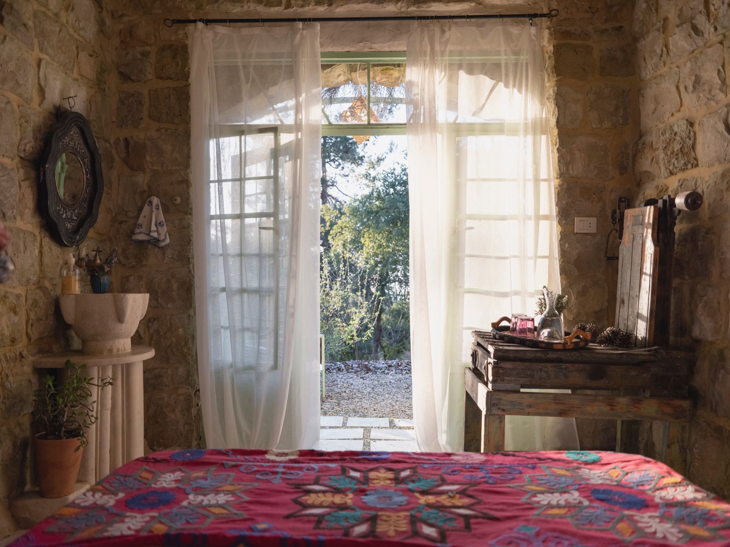 The Ermite room, with a kilim rug across the floor and French doors standing open onto the garden